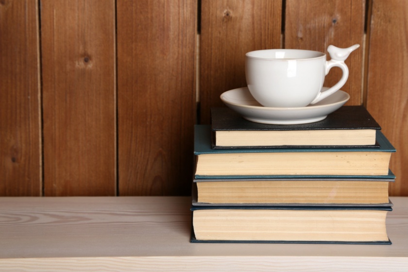 © Africa Studio / Fotolia.com -Pile of books with cup on tabletop and wooden background